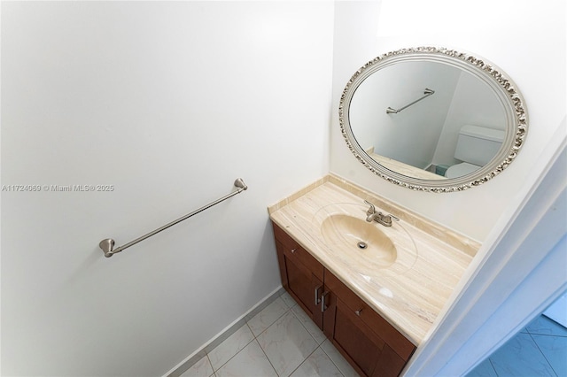 bathroom with toilet, tile patterned floors, and vanity