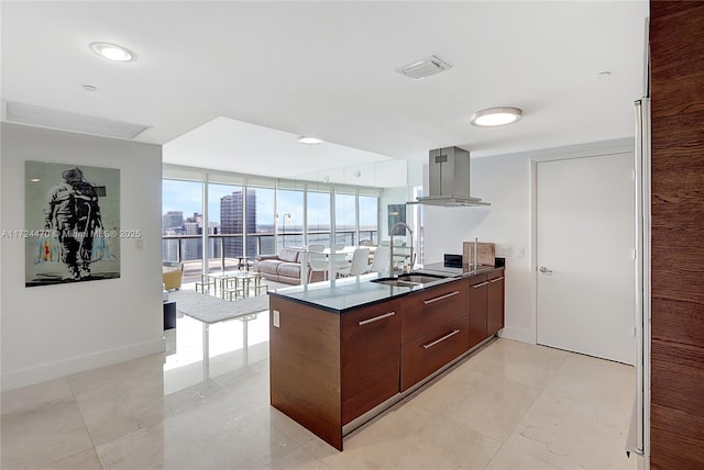 kitchen featuring floor to ceiling windows, sink, dark brown cabinets, island range hood, and kitchen peninsula