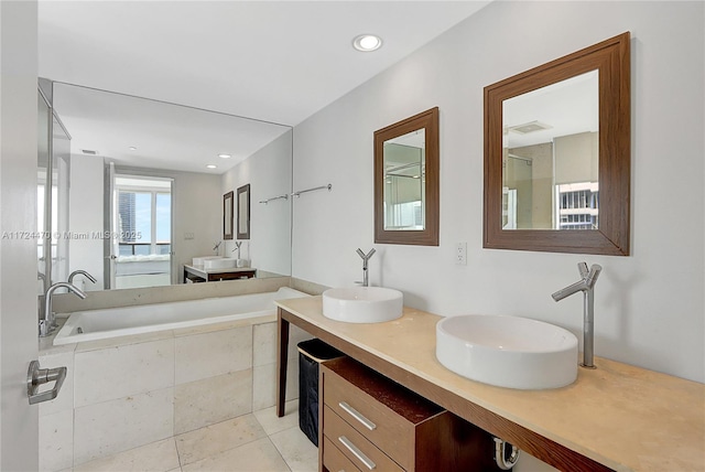 bathroom with tile patterned floors, vanity, and a relaxing tiled tub