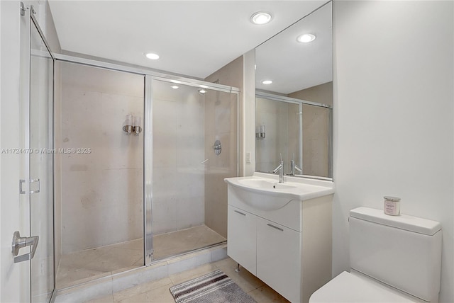 bathroom featuring vanity, toilet, and a shower with shower door