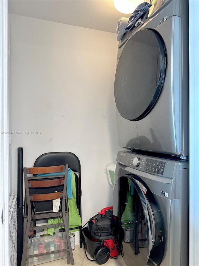 clothes washing area with stacked washer / dryer