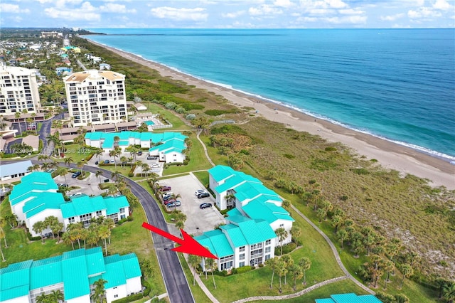 drone / aerial view with a water view and a beach view