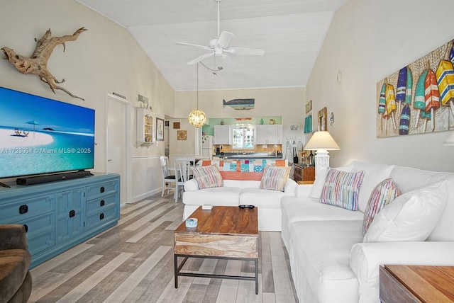 living room featuring light wood-style flooring, high vaulted ceiling, and ceiling fan