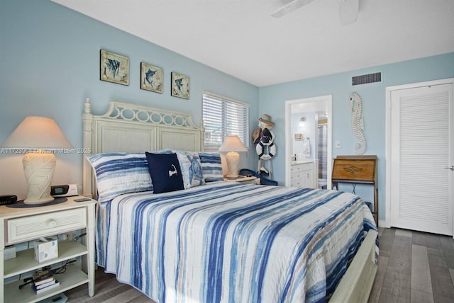 bedroom featuring ensuite bathroom, wood finished floors, visible vents, and a ceiling fan