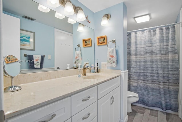 full bathroom featuring toilet, a shower with curtain, visible vents, and vanity