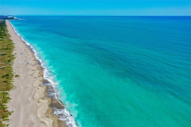 drone / aerial view featuring a beach view and a water view