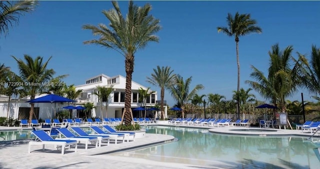 pool with a patio area and fence