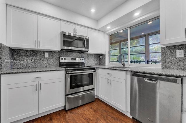 kitchen featuring stone counters, sink, stainless steel appliances, dark hardwood / wood-style flooring, and white cabinets