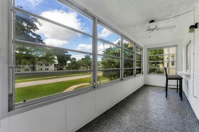 unfurnished sunroom with ceiling fan