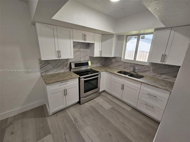 kitchen featuring white cabinetry, light wood-type flooring, stainless steel electric stove, light stone counters, and sink