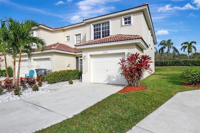 mediterranean / spanish home featuring a front yard and a garage