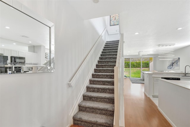 staircase featuring sink and wood-type flooring