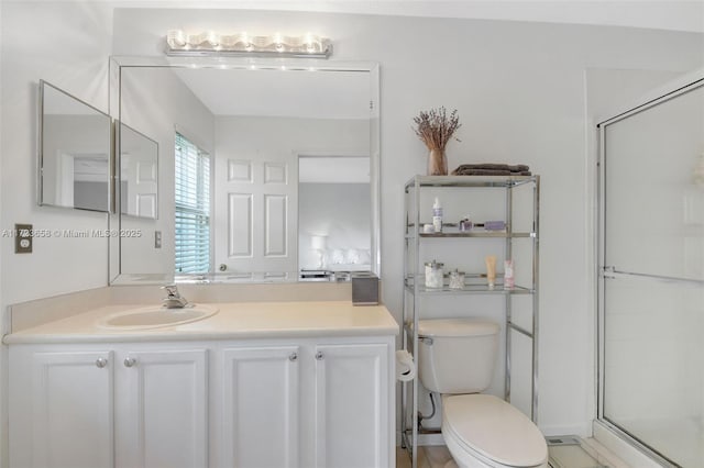 bathroom with toilet, a shower with door, and vanity