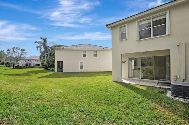 back of property featuring a lawn and cooling unit