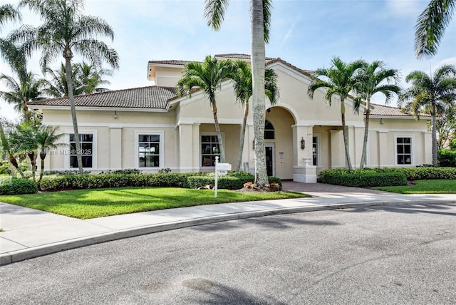 mediterranean / spanish-style home with a front lawn