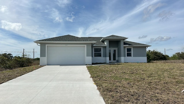 view of front of house featuring a garage, a front yard, and french doors