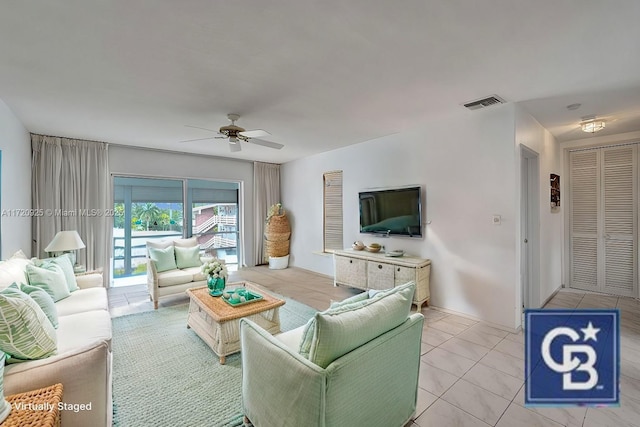 tiled living room with ceiling fan