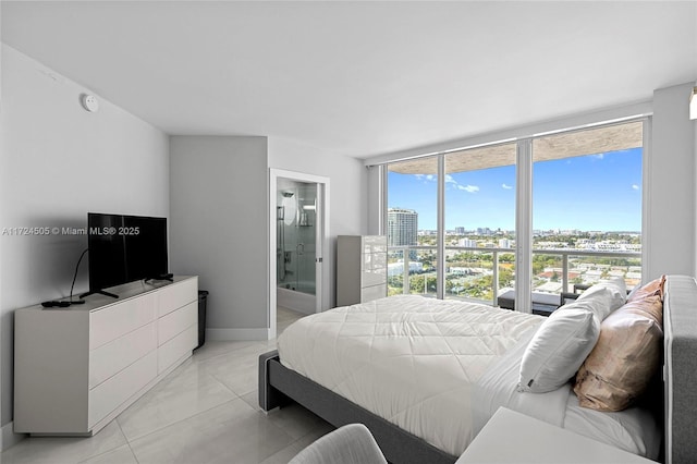 bedroom with light tile patterned floors, baseboards, ensuite bathroom, and a wall of windows