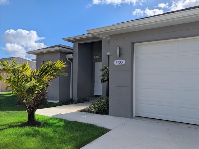 doorway to property featuring a garage and a yard