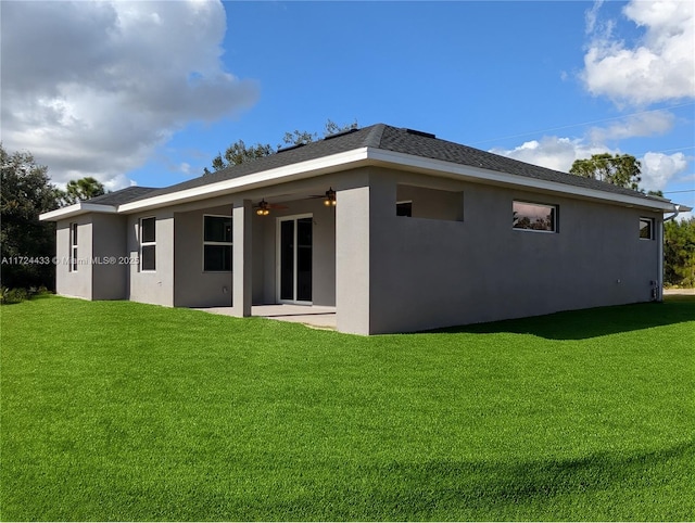 back of property with a lawn, ceiling fan, and a patio