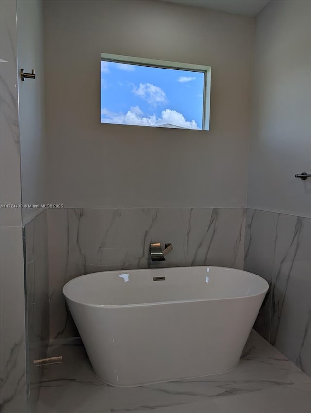 bathroom featuring a washtub and a wealth of natural light