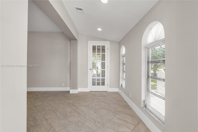 spare room with french doors and vaulted ceiling