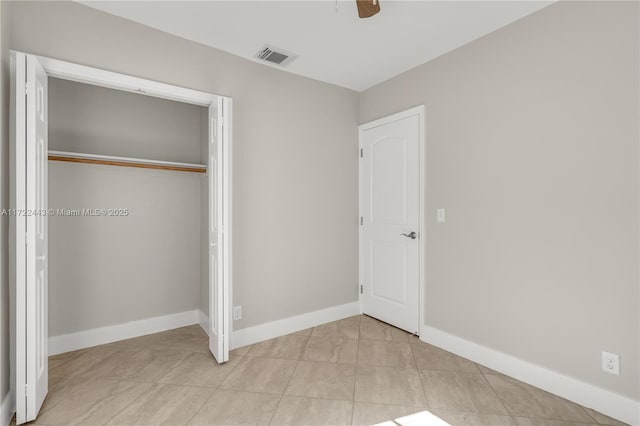 unfurnished bedroom with ceiling fan, a closet, and light tile patterned floors