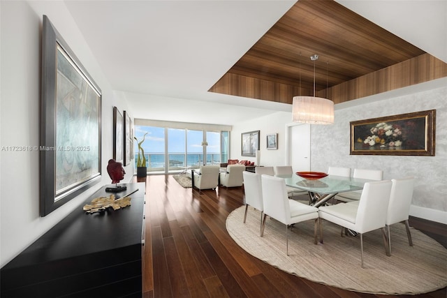 dining area featuring a tray ceiling, a water view, wood ceiling, and hardwood / wood-style flooring