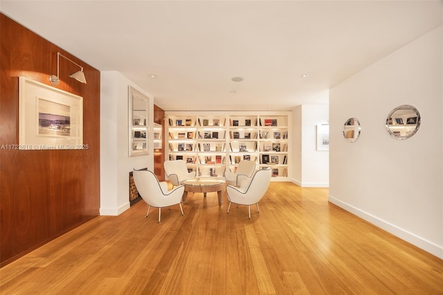 unfurnished room featuring built in shelves and light hardwood / wood-style flooring