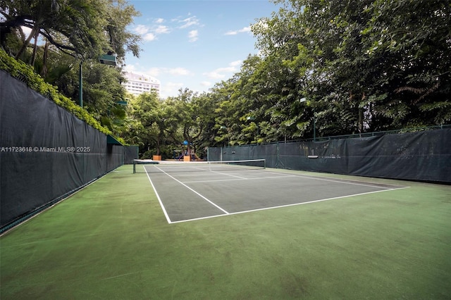 view of tennis court featuring a playground