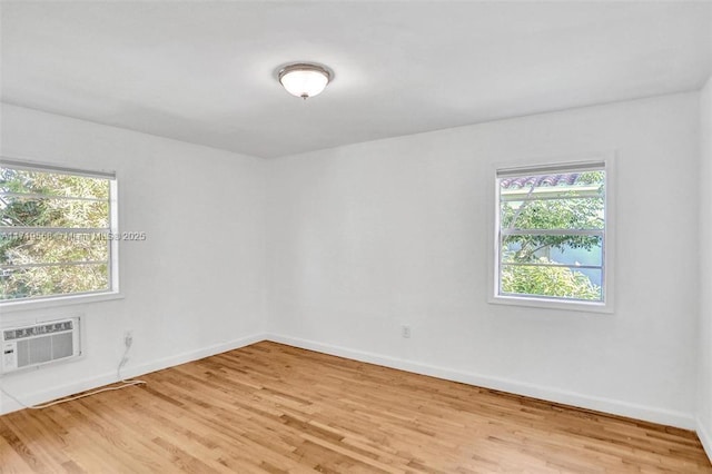 empty room featuring light hardwood / wood-style flooring and a wall mounted air conditioner