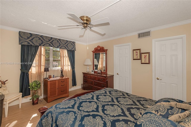 bedroom featuring ceiling fan, crown molding, and a textured ceiling