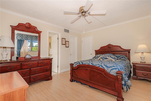 bedroom with a textured ceiling, ceiling fan, and ornamental molding