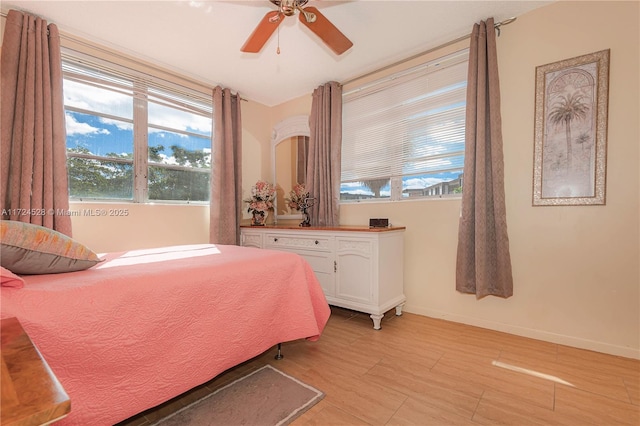 bedroom with multiple windows, light hardwood / wood-style flooring, and ceiling fan