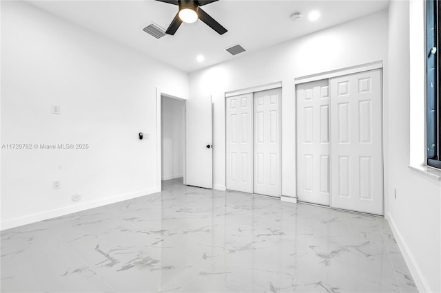 unfurnished bedroom featuring multiple closets and ceiling fan