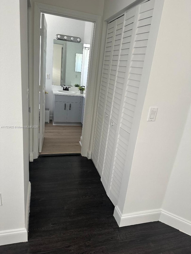 hallway featuring sink and dark wood-type flooring