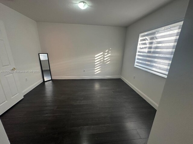 empty room featuring dark hardwood / wood-style flooring