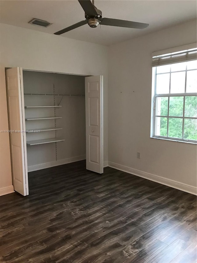 unfurnished bedroom with a closet, ceiling fan, and dark hardwood / wood-style floors