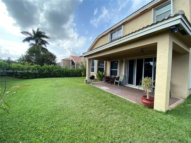 view of yard with ceiling fan and a patio area