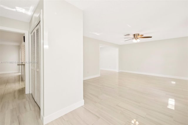 empty room with ceiling fan and light hardwood / wood-style floors