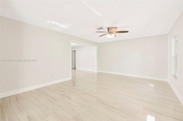 empty room with ceiling fan and light hardwood / wood-style floors