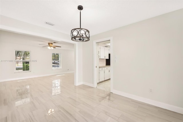 interior space with ceiling fan with notable chandelier