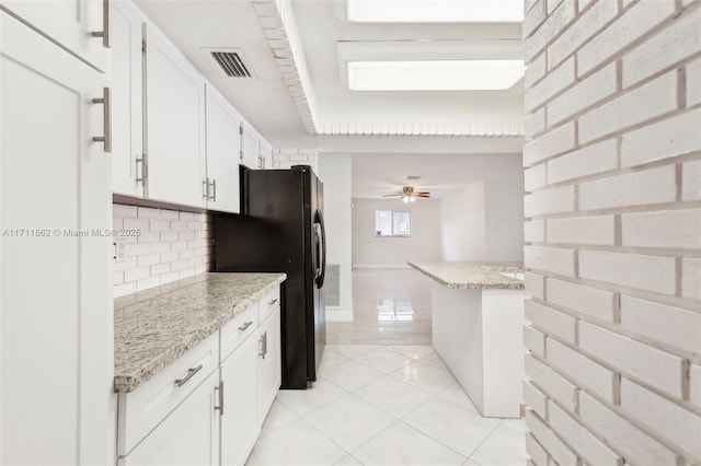 kitchen featuring backsplash, ceiling fan, light tile patterned floors, light stone counters, and white cabinetry