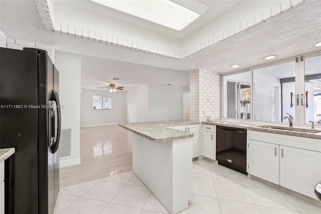 kitchen with black appliances, kitchen peninsula, ceiling fan, light tile patterned floors, and white cabinetry