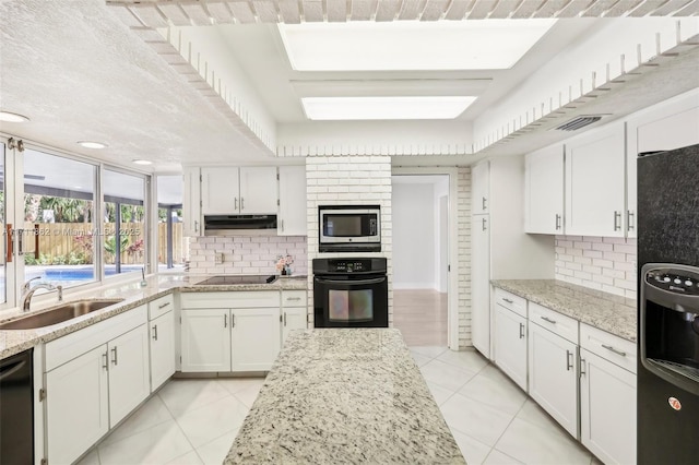 kitchen featuring white cabinets, light tile patterned floors, sink, and black appliances