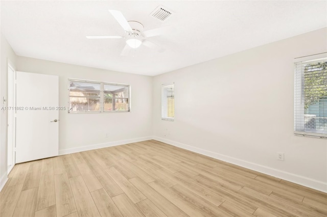 empty room with ceiling fan, a healthy amount of sunlight, and light hardwood / wood-style floors