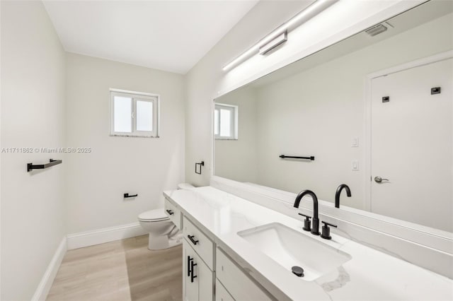 bathroom featuring wood-type flooring, vanity, and toilet