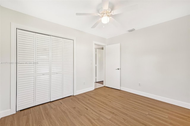 unfurnished bedroom featuring ceiling fan, a closet, and light hardwood / wood-style flooring