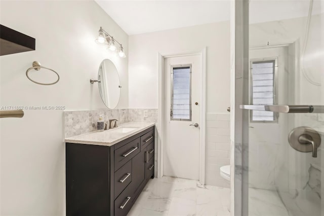 bathroom featuring a shower, vanity, and toilet