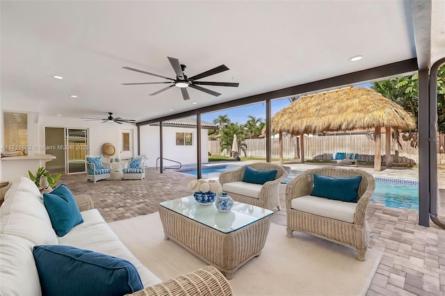 view of patio with a gazebo, ceiling fan, a fenced in pool, and an outdoor hangout area